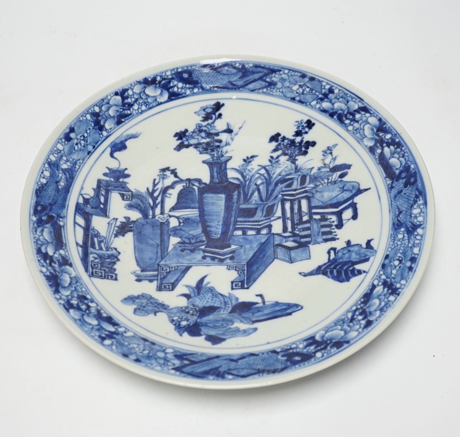 A 19th century Chinese blue and white ‘Hundred Antiques’ dish, with fish to the border, 30cm in diameter